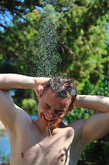 Image showing young man relaxing under shower