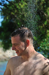 Image showing young man relaxing under shower