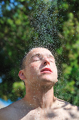 Image showing young man relaxing under shower