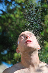 Image showing young man relaxing under shower