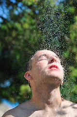 Image showing young man relaxing under shower