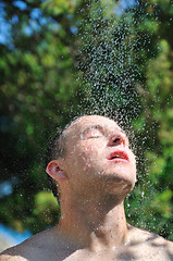 Image showing young man relaxing under shower