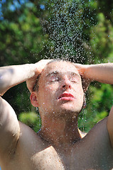 Image showing young man relaxing under shower