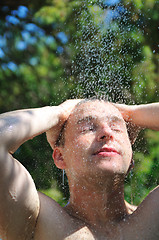 Image showing young man relaxing under shower