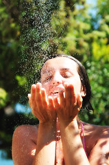 Image showing beautiful woman washing and cleaning face under shower