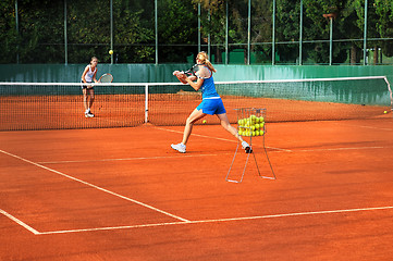 Image showing Two young women playing tennis outdoors on Two young womwn playi