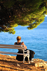 Image showing Single woman sitting alone by the beach 