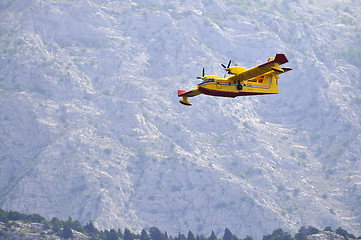 Image showing Airplane droping water on fire 