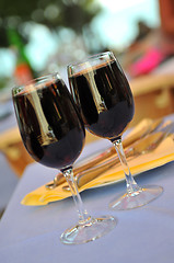 Image showing two glasses in outside restaurant with black wine