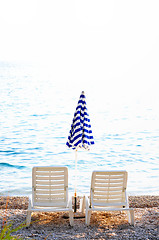 Image showing empty chairs on beach with umbrella