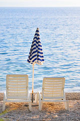 Image showing empty chairs on beach with umbrella