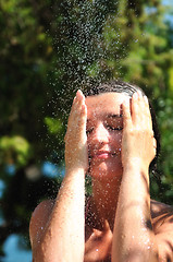 Image showing beautiful woman washing and cleaning face under shower