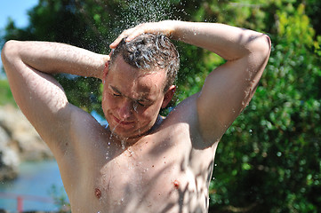 Image showing young man relaxing under shower