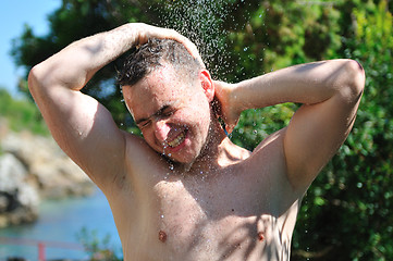 Image showing young man relaxing under shower