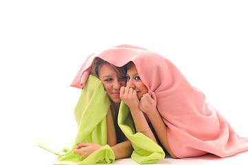 Image showing young girls under blanket smile