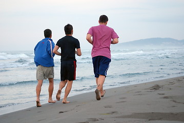 Image showing three friends jogging at beach