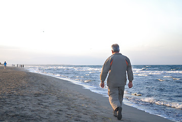 Image showing lonely older  man walking on beach