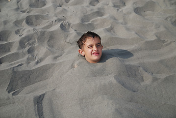 Image showing happy children buried in sand