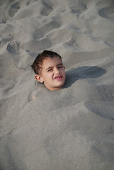 Image showing happy children buried in sand