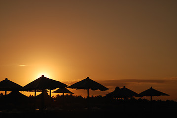 Image showing sunshine on beach with beach umbrellas silhouette