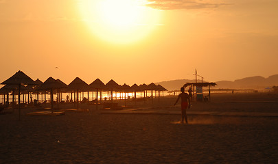 Image showing sunshine on beach with beach umbrellas silhouette