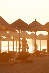 Image showing sunshine on beach with beach umbrellas silhouette