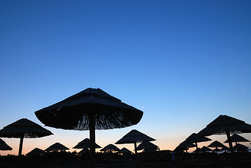 Image showing sunshine on beach with beach umbrellas silhouette