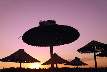 Image showing sunshine on beach with beach umbrellas silhouette