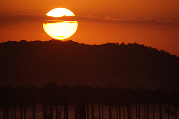 Image showing sunshine on beach with beach umbrellas silhouette