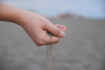 Image showing fine sand leaking trought woman hands