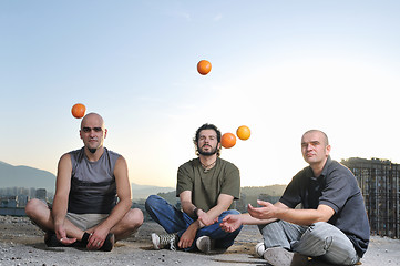 Image showing three man outdoor play with orange fruit