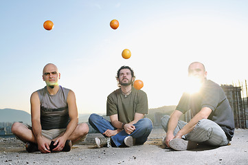 Image showing three man outdoor play with orange fruit