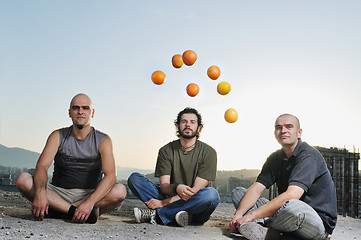 Image showing three man outdoor play with orange fruit