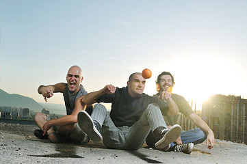 Image showing three man outdoor play with orange fruit