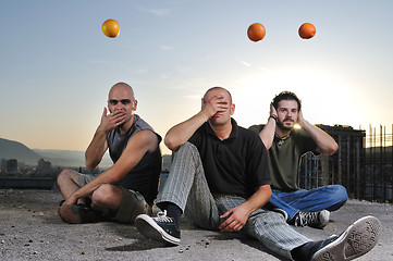 Image showing three man outdoor play with orange fruit