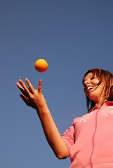 Image showing female hand balancing iorange in air