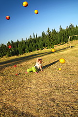 Image showing happy girl throwing apple outside