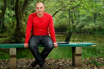 Image showing young businessman working on laptop outdoor