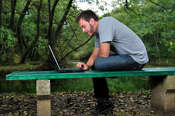 Image showing young businessman working on laptop outdoor