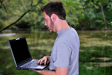 Image showing young businessman working on laptop outdoor