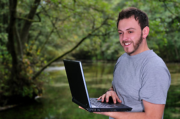 Image showing young businessman with  laptop outdoor