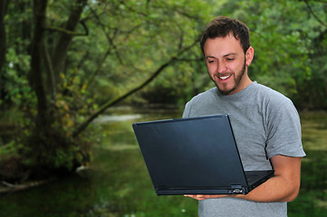 Image showing young businessman working on laptop outdoor