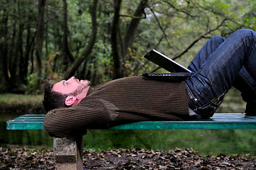 Image showing young businessman working on laptop outdoor