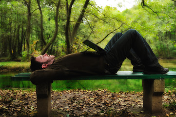 Image showing young businessman working on laptop outdoor