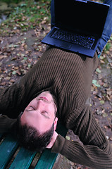 Image showing young businessman working on laptop outdoor