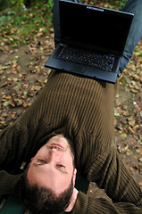 Image showing young businessman working on laptop outdoor