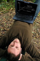 Image showing young businessman working on laptop outdoor