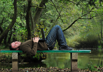 Image showing young businessman working on laptop outdoor