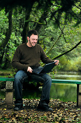 Image showing young businessman working on laptop outdoor