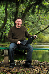 Image showing young businessman working on laptop outdoor